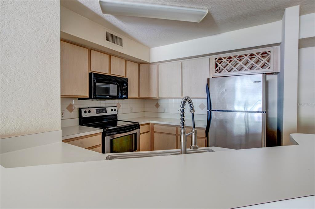823 Camargo Way, Unit 101 Altamonte Springs, FL 32714 - Photo 5 of 20 a kitchen with a refrigerator a microwave a sink and cabinets