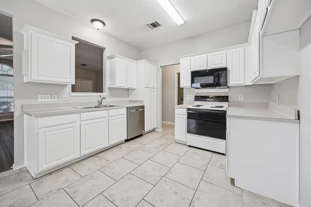 a kitchen with white cabinets stainless steel appliances and sink