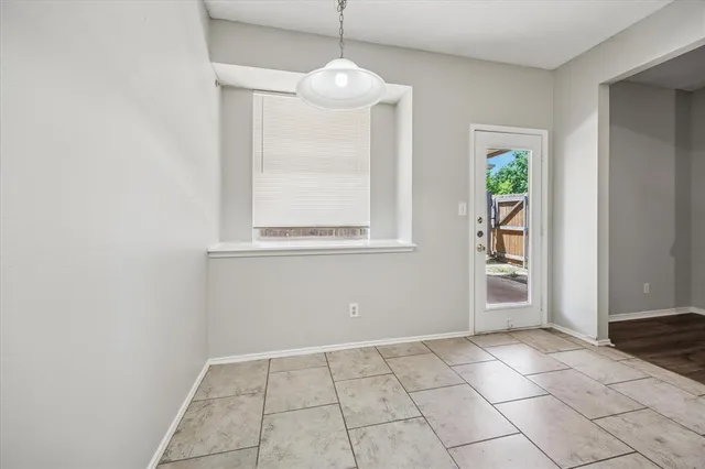a view of an empty room with window and cabinet
