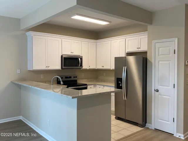 a kitchen with stainless steel appliances a refrigerator a sink a stove a microwave and cabinets