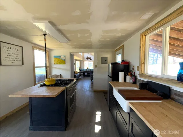 a kitchen with a stove a sink a dining table and chairs