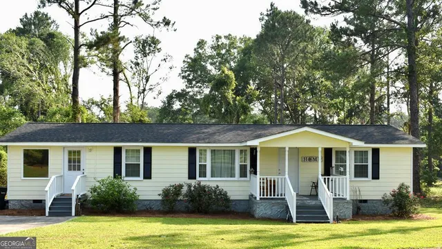 a front view of house with yard and trees around