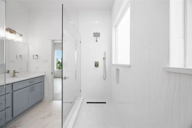 a bathroom with a double vanity sink a toilet and shower