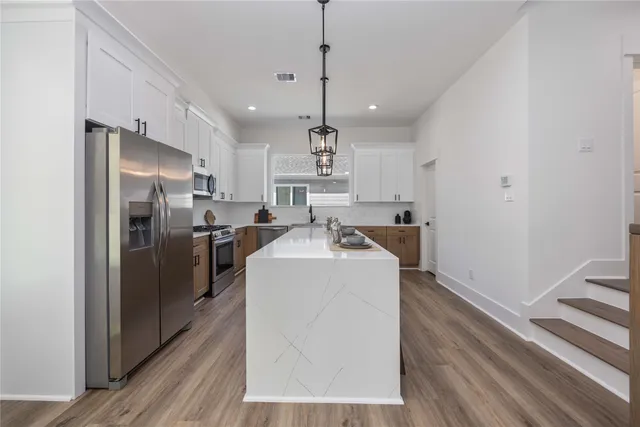 a kitchen with refrigerator a oven and white walls