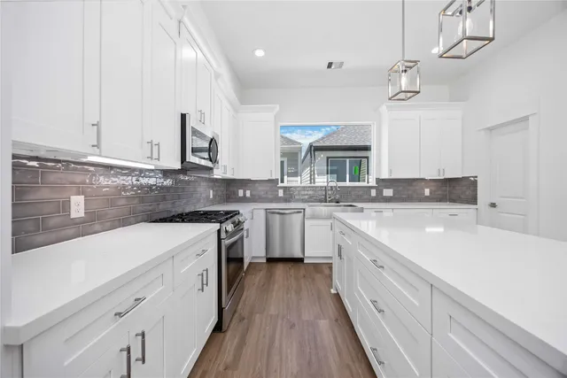 a kitchen with a sink cabinets a counter top space and stainless steel appliances