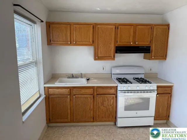 a kitchen with a stove sink and cabinets