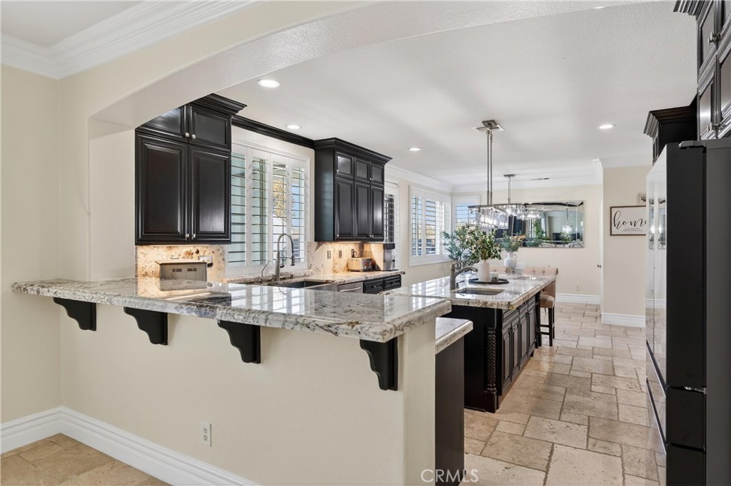 2634 Old Windmill Court Riverside, CA 92503 - Photo 21 of 44 a kitchen with kitchen island granite countertop a sink appliances and cabinets