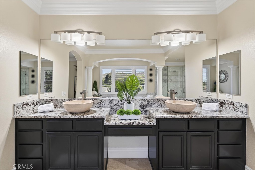 2634 Old Windmill Court Riverside, CA 92503 - Photo 32 of 44 a bathroom with a granite countertop sink a large mirror and a chandelier
