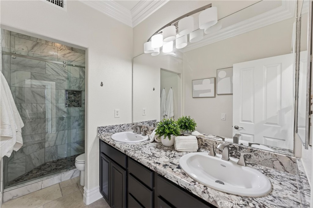 2634 Old Windmill Court Riverside, CA 92503 - Photo 33 of 44 a bathroom with a granite countertop double vanity sink mirror and shower