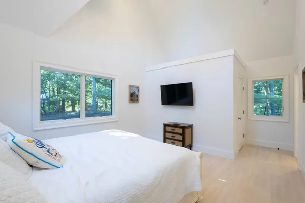a bedroom with a bed and a large window
