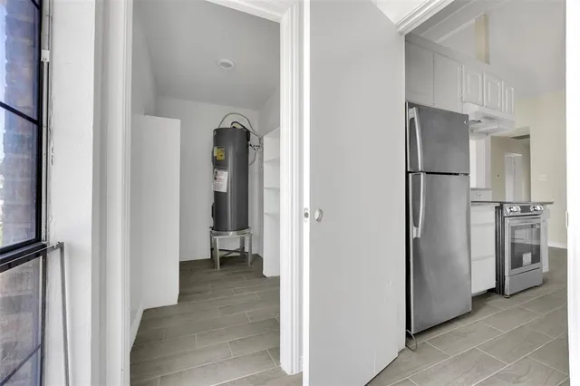 a view of a hallway with wooden floor and closet