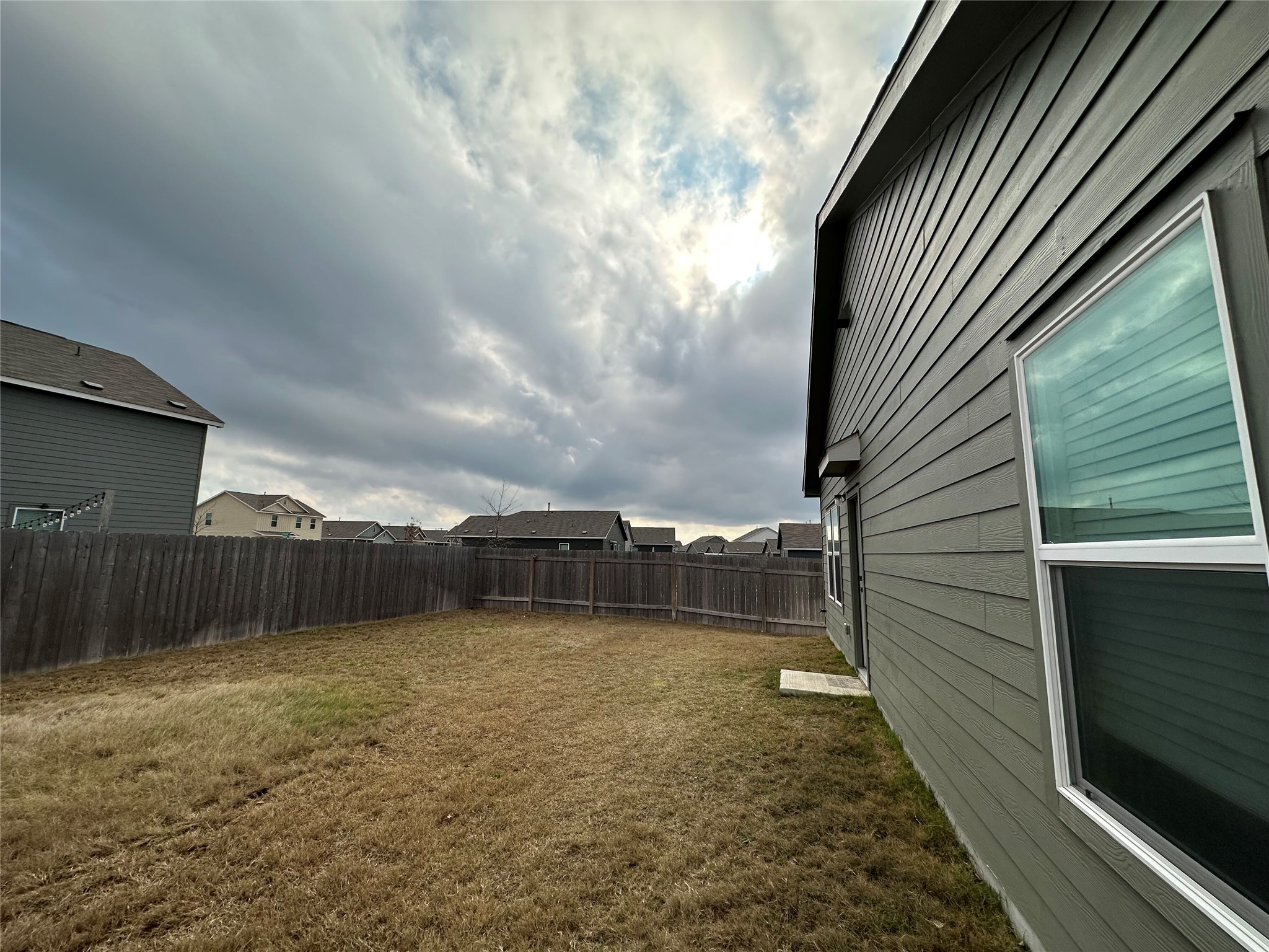 13501 Mussel Run Elgin, TX 78621 - Photo 19 of 28 Expansive backyard featuring a full privacy fence, established sod, and a concrete patio pad