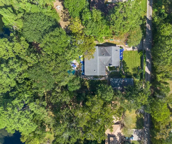 a view of a house with a yard and large trees