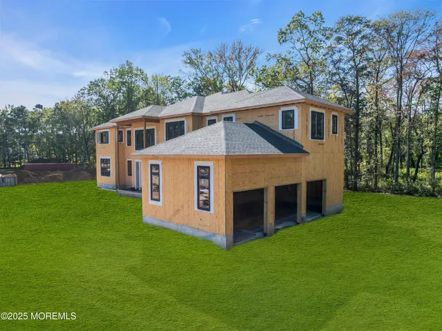a front view of a house with a yard and trees
