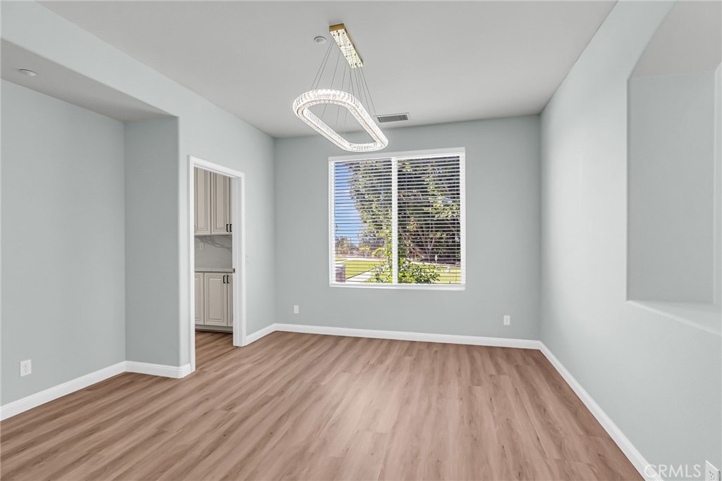 7535 Misty View Place Riverside, CA 92506 - Photo 42 of 75 an empty room with wooden floor exposed radiator and windows