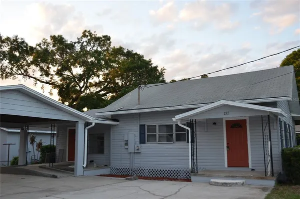 a front view of a house with a tree