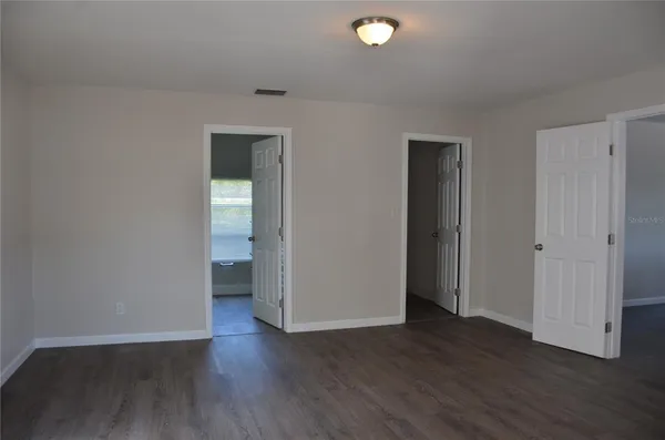 an empty room with wooden floor and window