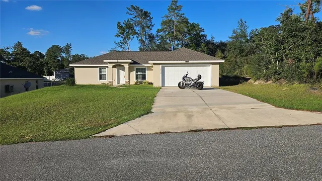 a front view of a house with a garden and yard