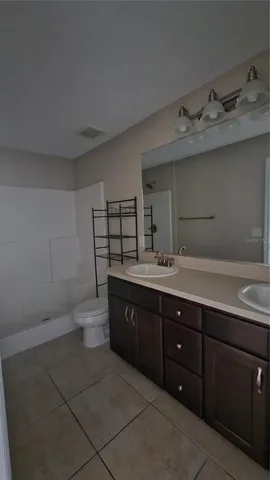 a bathroom with a granite countertop sink a toilet and a mirror