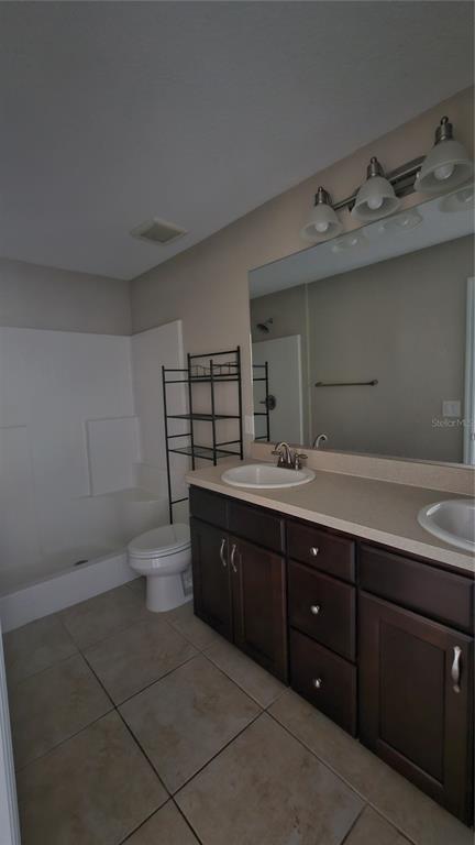 15944 Southwest 53rd Court Ocala, FL 34473 - Photo 14 of 22 a bathroom with a granite countertop sink a toilet and a mirror