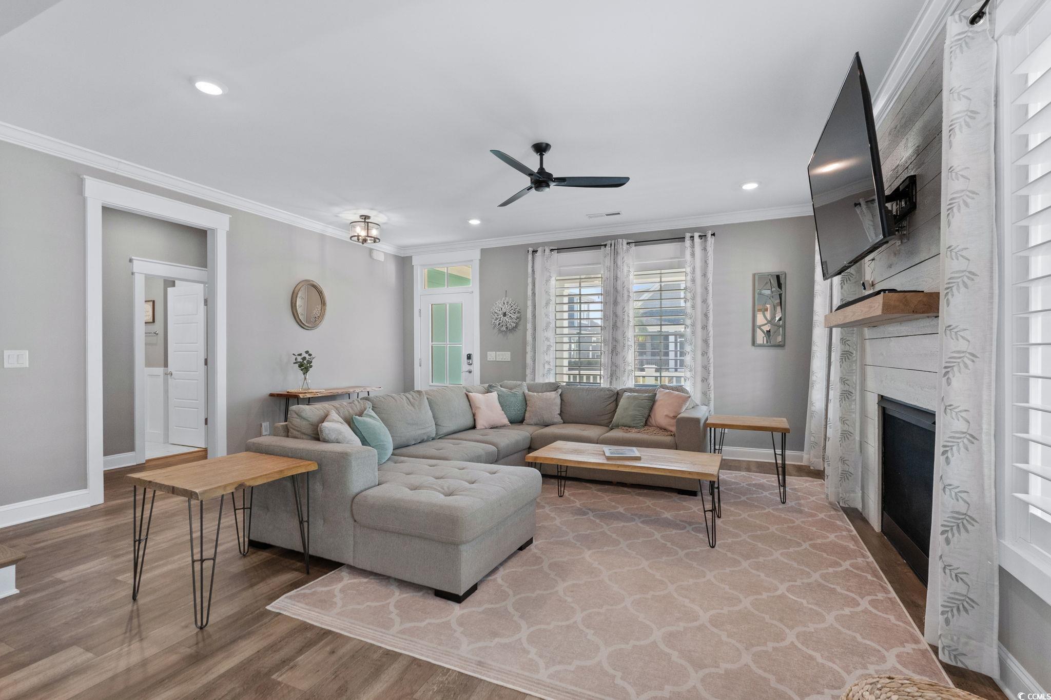 8336 Sandlapper Way Myrtle Beach, SC 29572 - Photo 11 of 40 Living area with ornamental molding, a premium fireplace, wood finished floors, a ceiling fan, and recessed lighting