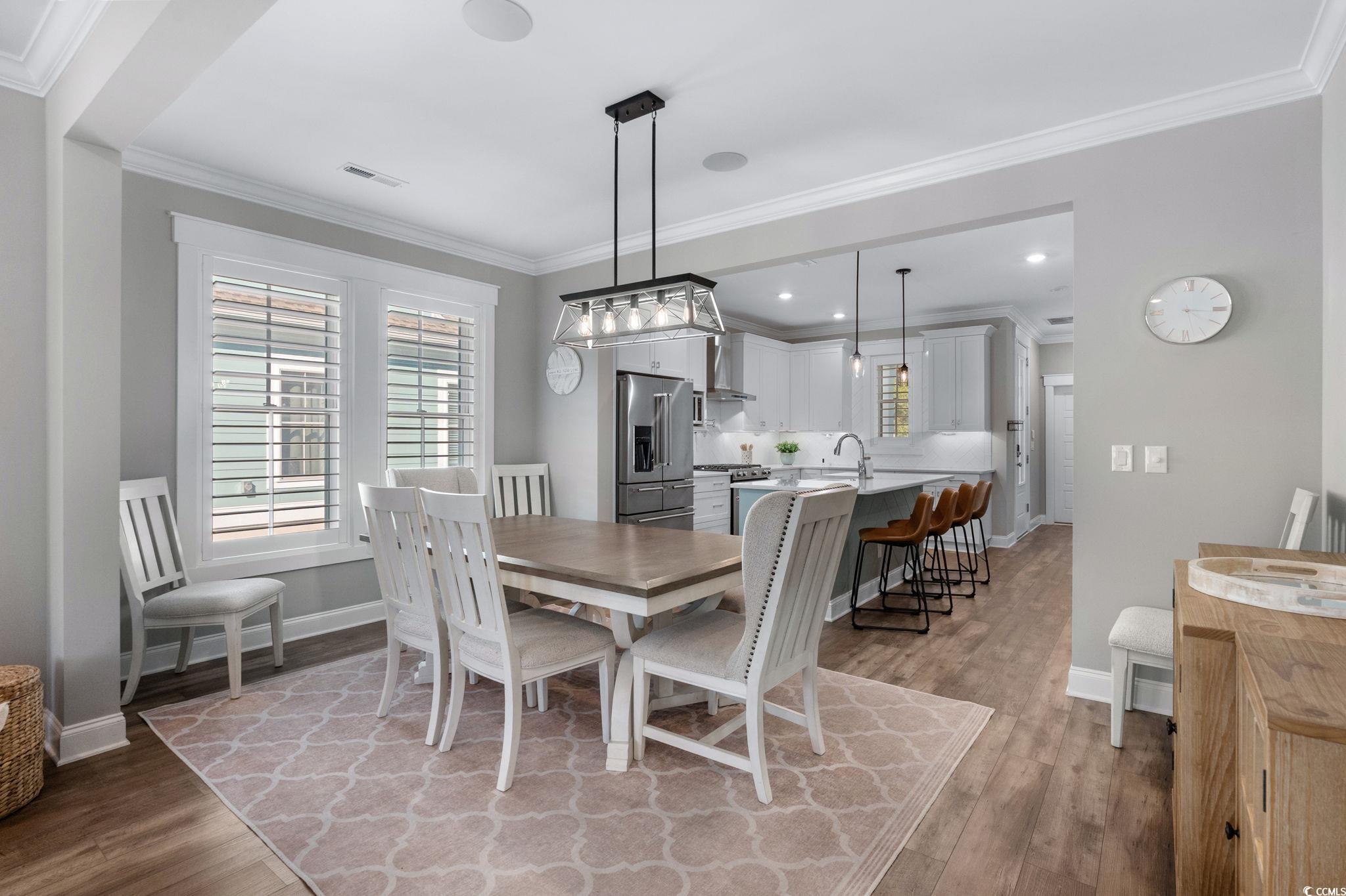 8336 Sandlapper Way Myrtle Beach, SC 29572 - Photo 14 of 40 Dining room with healthy amount of natural light, ornamental molding, and light wood finished floors