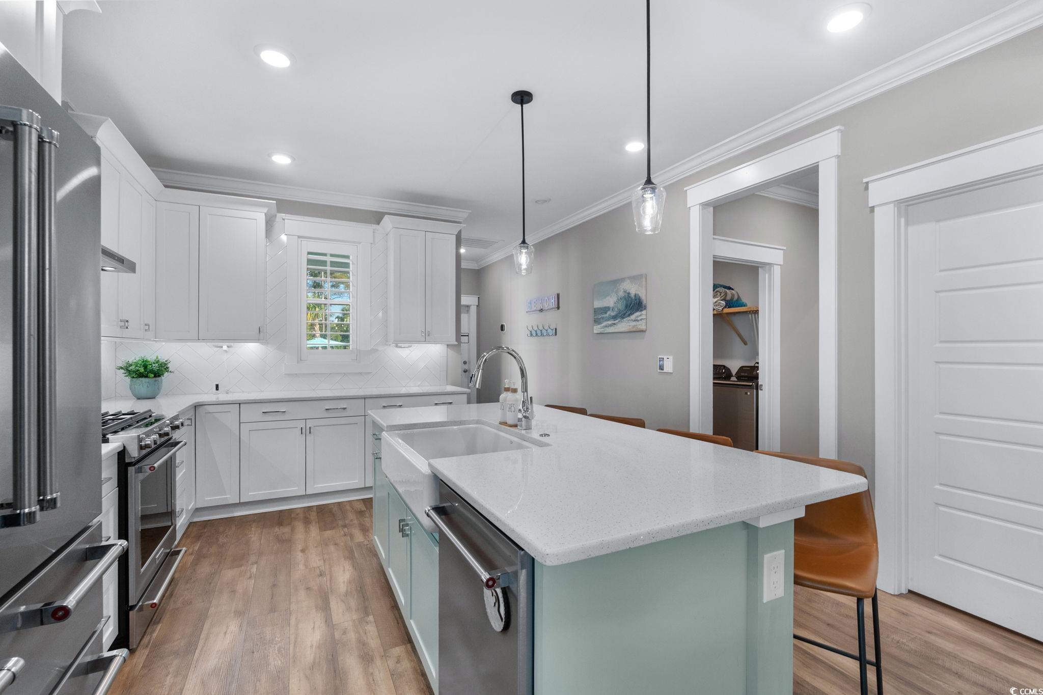 8336 Sandlapper Way Myrtle Beach, SC 29572 - Photo 17 of 40 Kitchen with light wood-style floors, light stone countertops, appliances with stainless steel finishes, crown molding, and recessed lighting