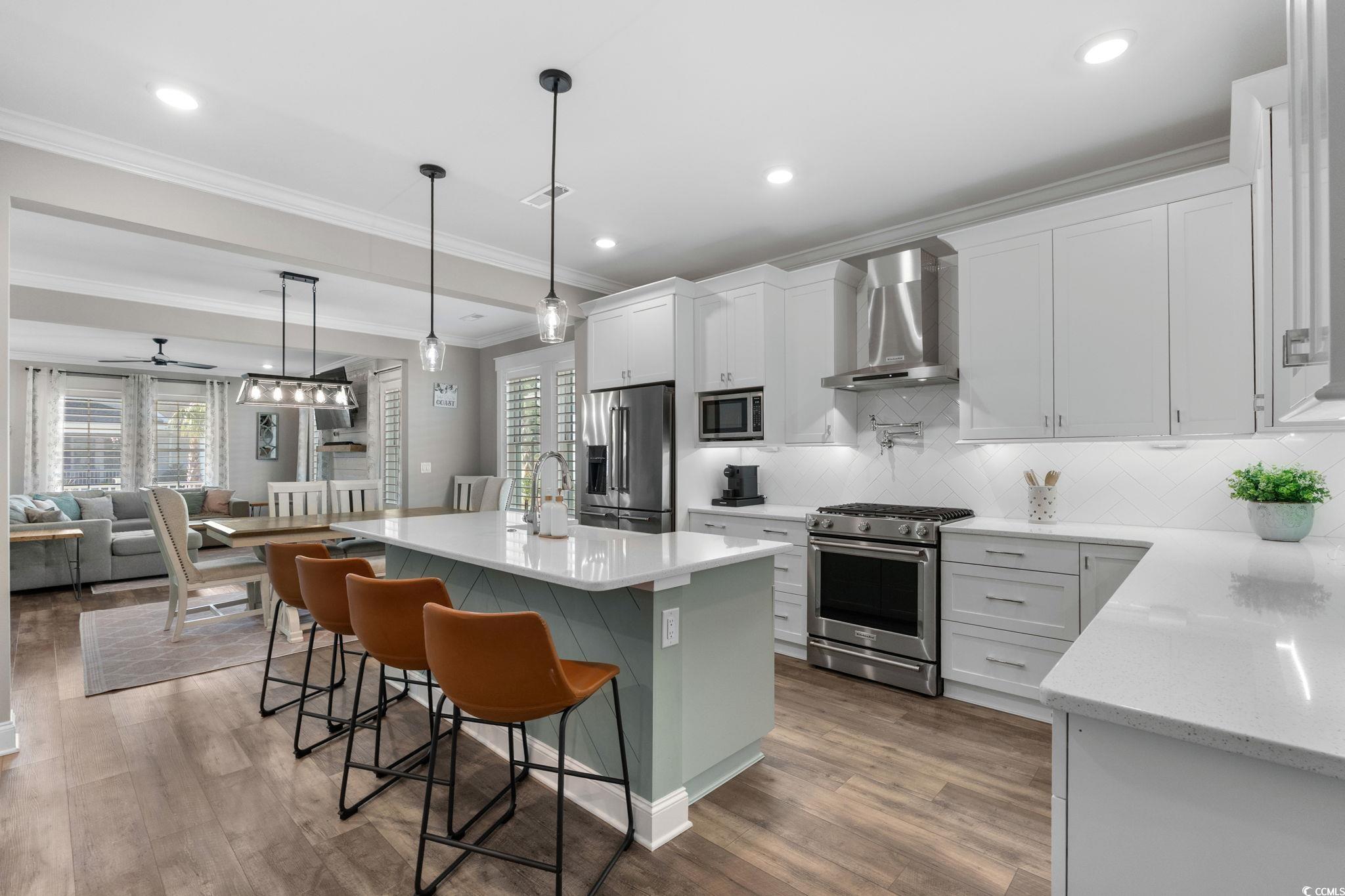 8336 Sandlapper Way Myrtle Beach, SC 29572 - Photo 40 of 40 Kitchen with crown molding, stainless steel appliances, decorative light fixtures, a kitchen island, and open floor plan