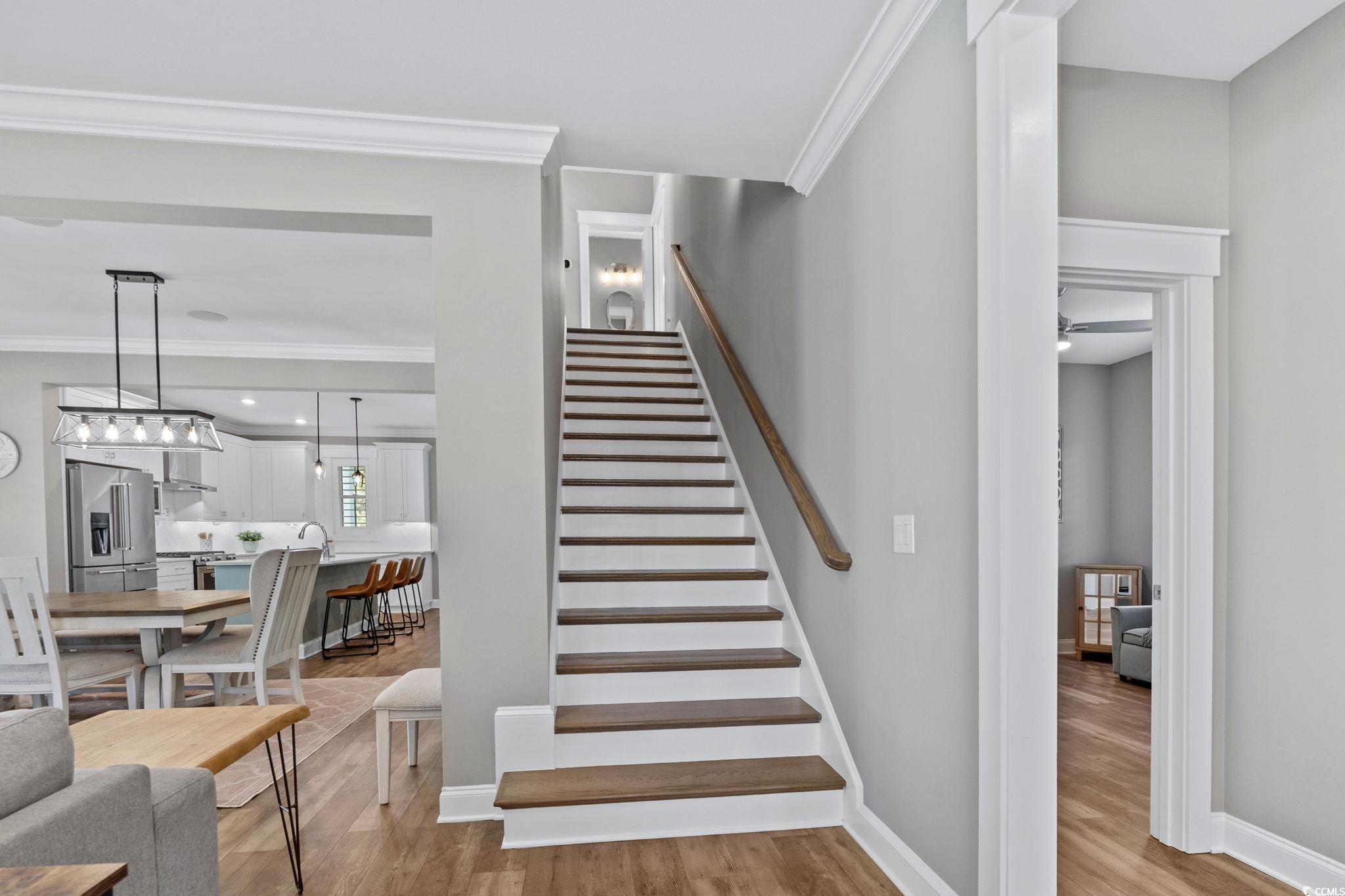 8336 Sandlapper Way Myrtle Beach, SC 29572 - Photo 19 of 40 Stairs with wood finished floors and crown molding