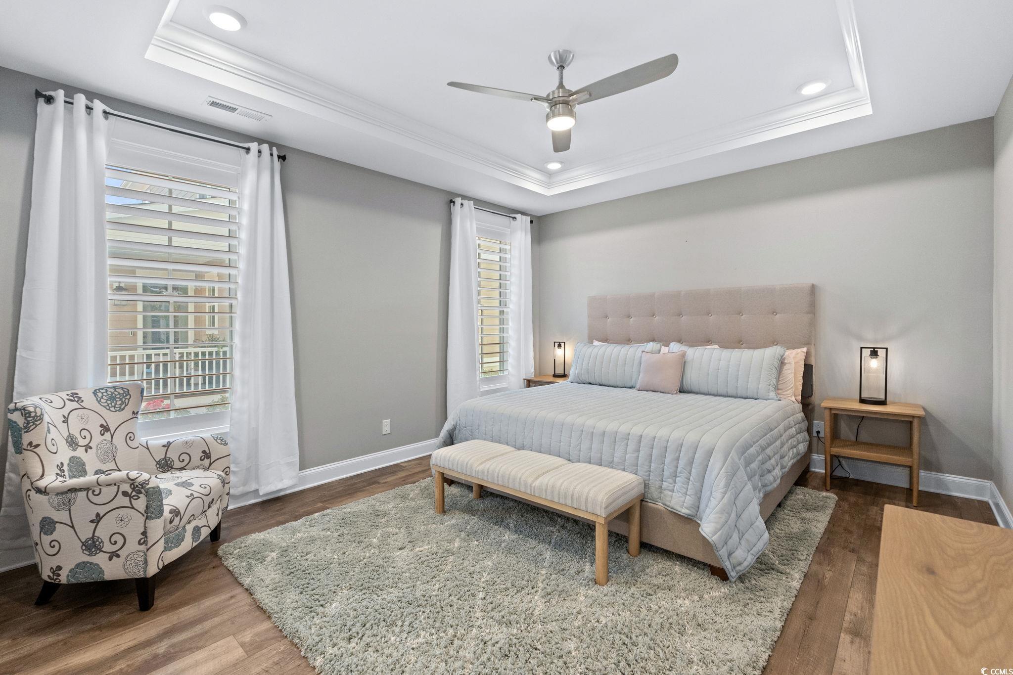 8336 Sandlapper Way Myrtle Beach, SC 29572 - Photo 20 of 40 Bedroom with a tray ceiling, wood finished floors, multiple windows, ornamental molding, and recessed lighting