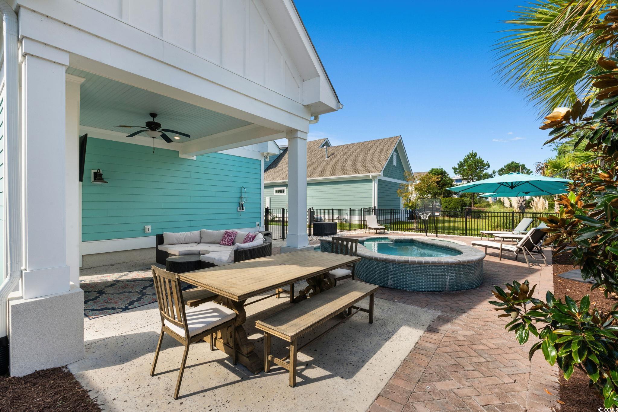 8336 Sandlapper Way Myrtle Beach, SC 29572 - Photo 31 of 40 View of patio / terrace with an in-ground hot tub, ceiling fan, an outdoor hangout area, and outdoor dining space
