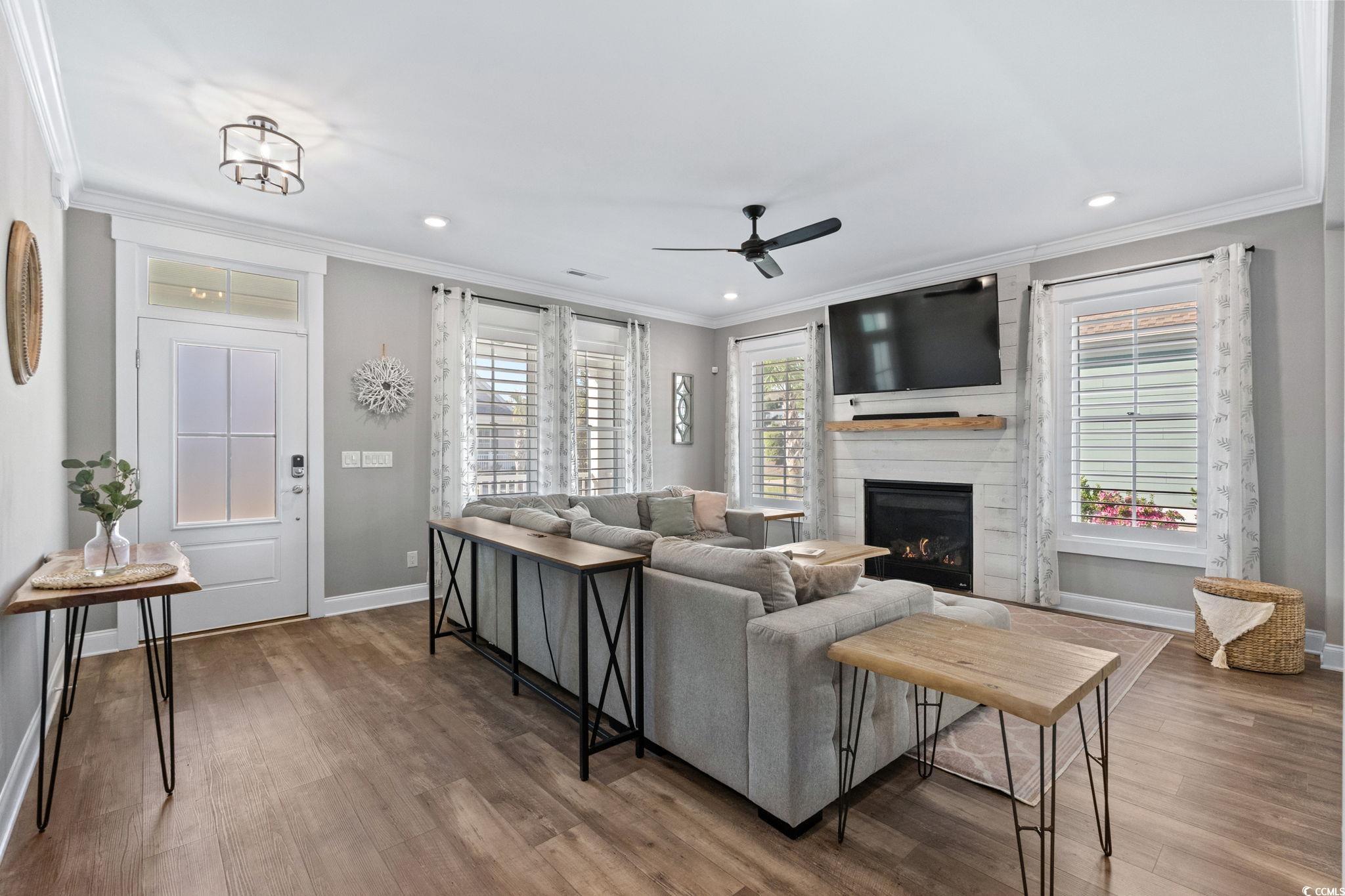 8336 Sandlapper Way Myrtle Beach, SC 29572 - Photo 10 of 40 Living area with crown molding, wood finished floors, a fireplace, ceiling fan, and recessed lighting