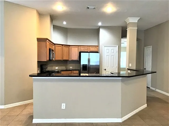 a kitchen with stainless steel appliances granite countertop a sink a stove and a refrigerator