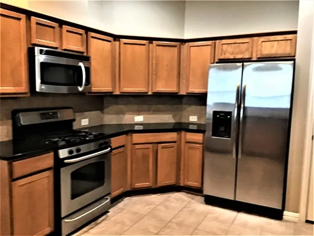a kitchen with stainless steel appliances granite countertop a stove microwave and refrigerator