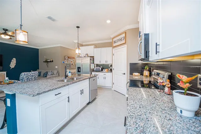 a kitchen with stainless steel appliances granite countertop a sink a stove and a refrigerator