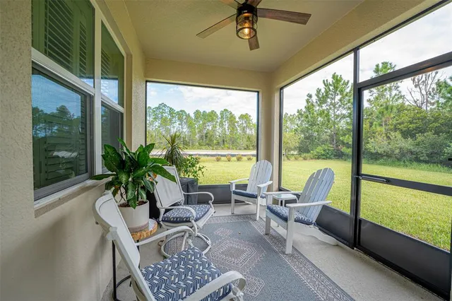 a living room with patio furniture and a floor to ceiling window