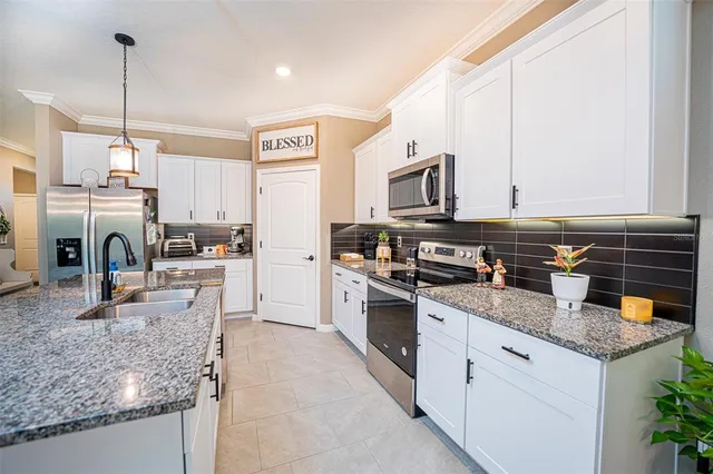 a kitchen with stainless steel appliances granite countertop a stove top oven a sink a counter space and cabinets