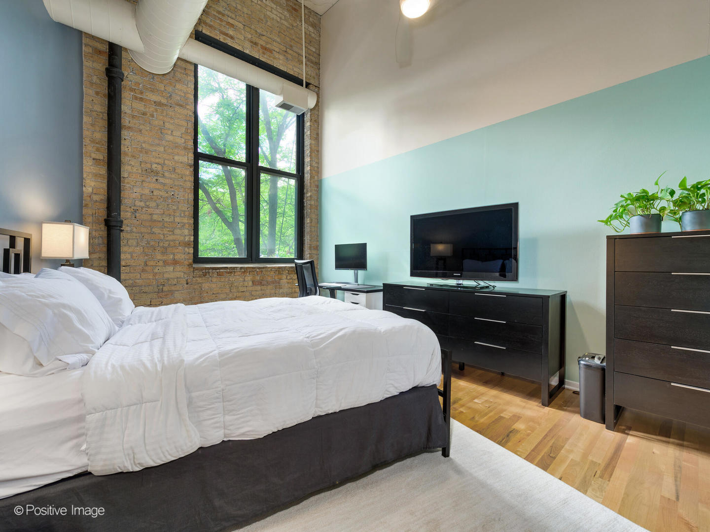 203 South Sangamon Street, Unit 213 Chicago, IL 60607 - Photo 14 of 23 a bedroom with a bed and a flat screen tv