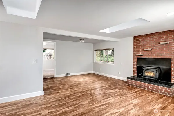 a view of an empty room with window and fire place