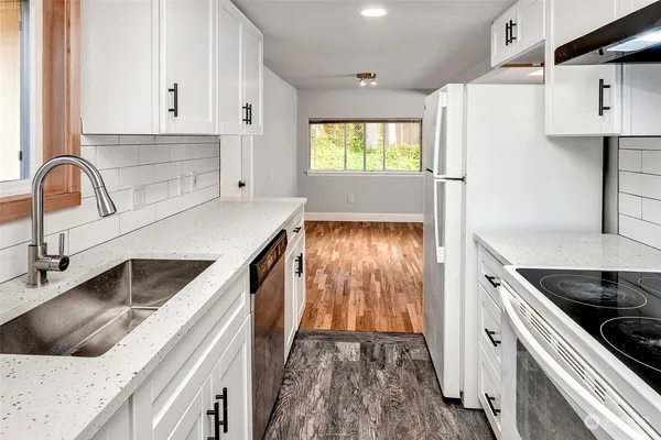 a kitchen with a white stove top oven and sink