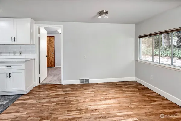 a view of a kitchen with wooden floor and a sink