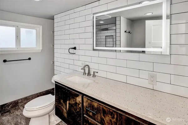 a bathroom with a sink a toilet and mirror