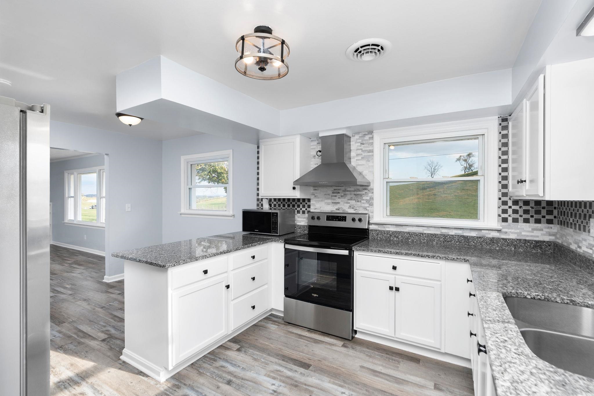 1111 Jennings Gap Road Churchville, VA 24421 - Photo 24 of 75 a kitchen with granite countertop a stove a sink and a refrigerator