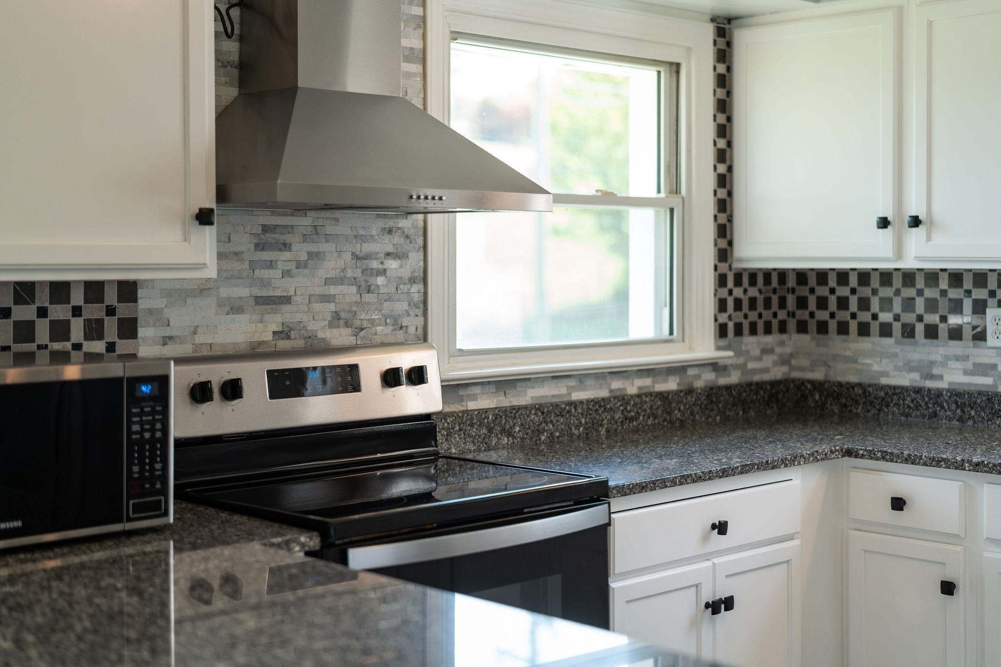 1111 Jennings Gap Road Churchville, VA 24421 - Photo 69 of 75 a kitchen with granite countertop a stove a sink and a microwave
