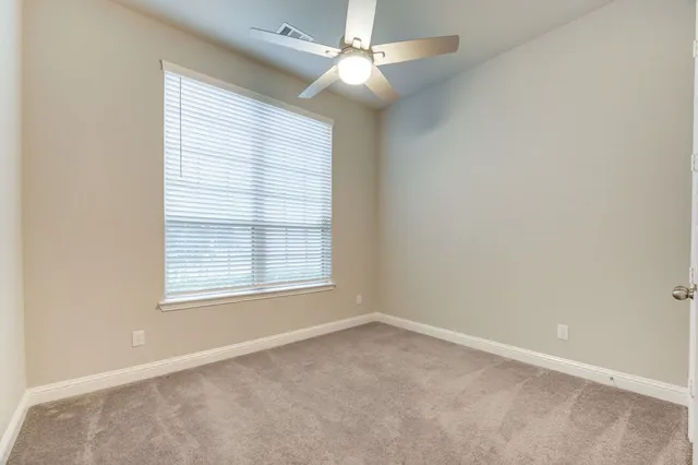 an empty room with closet and a chandelier fan