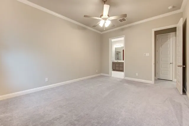 an empty room with closet and a ceiling fan