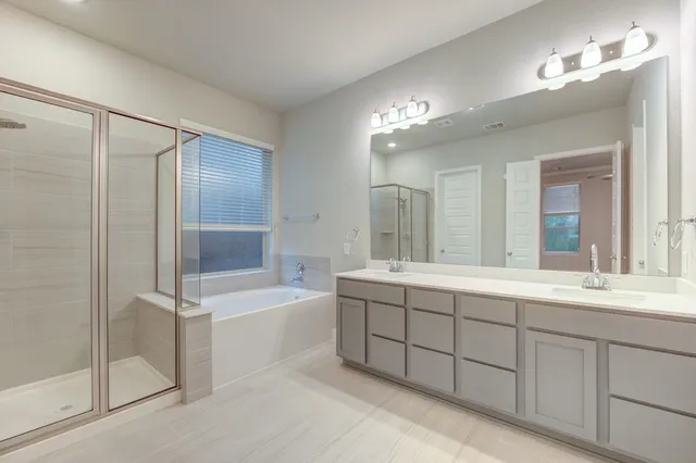 a bathroom with double vanity sink and a mirror