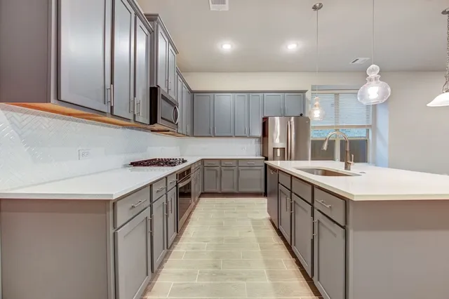 a kitchen with a refrigerator a sink and cabinets