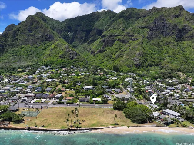 an aerial view of residential houses with outdoor space and trees