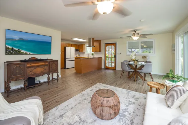 a living room with furniture a dining table and large windows